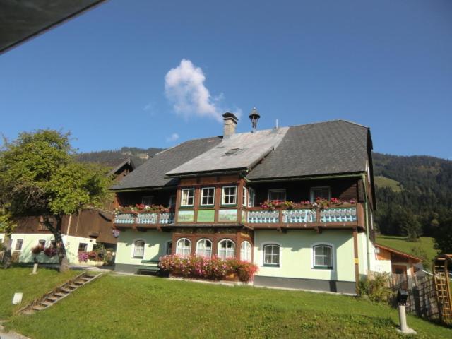 巴德米滕多夫邦茨拜恩霍夫农家乐的一座带黑色屋顶和鲜花的大房子