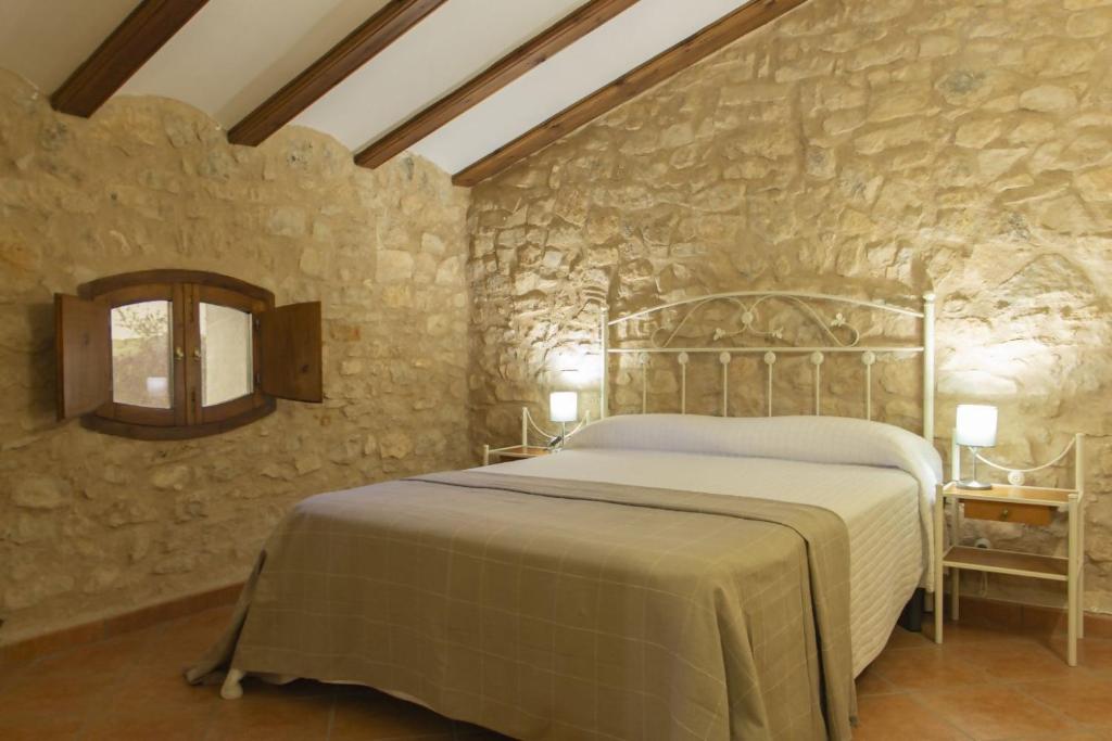 瓦德诺比斯Masia Villa Pilar Valderrobres的卧室配有一张石墙床