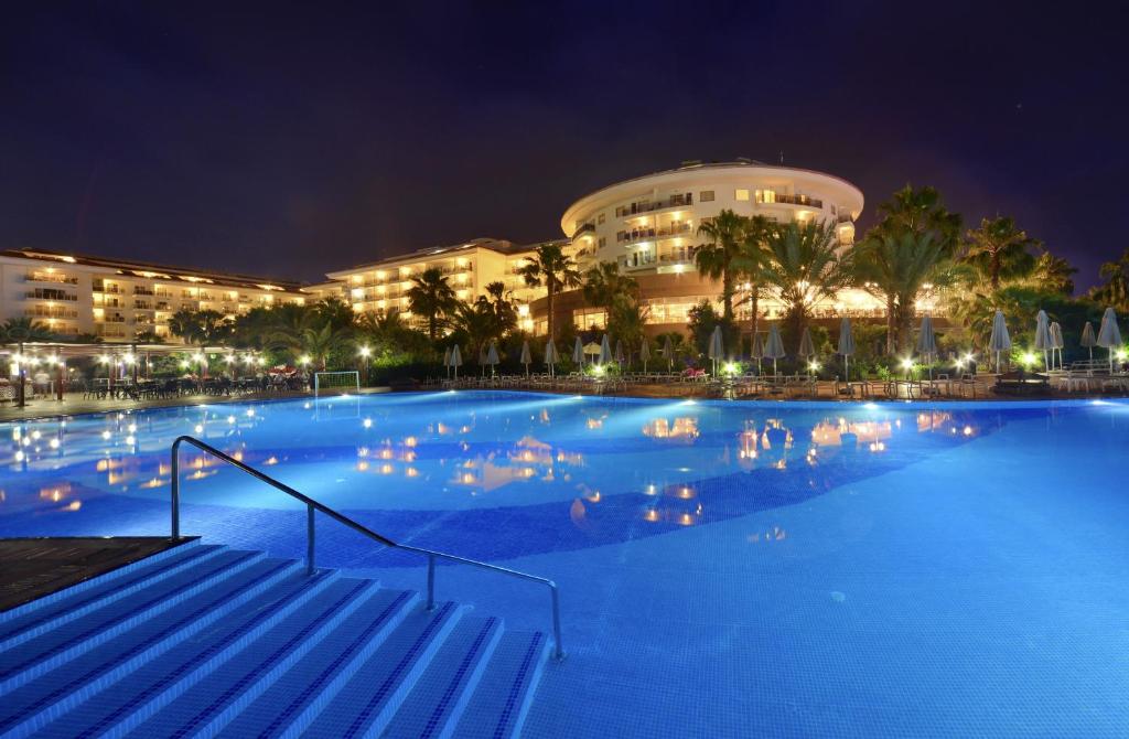 克孜拉阿奇Seaden Sea World Resort & Spa的一座大楼前的大型游泳池