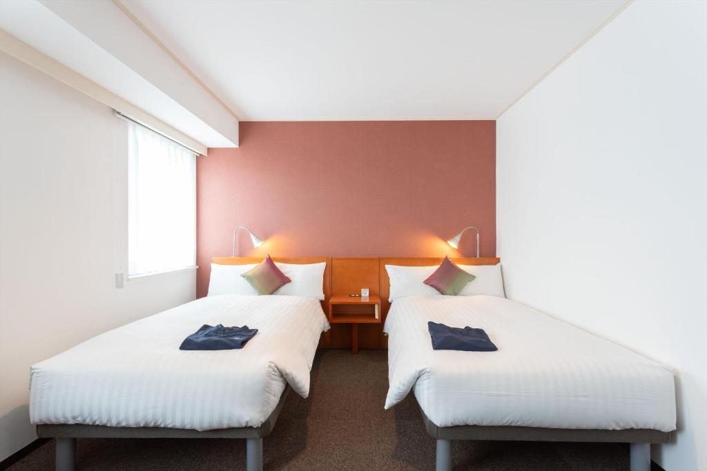 鹿儿岛Sun Days Kagoshima的红色墙壁客房的两张床