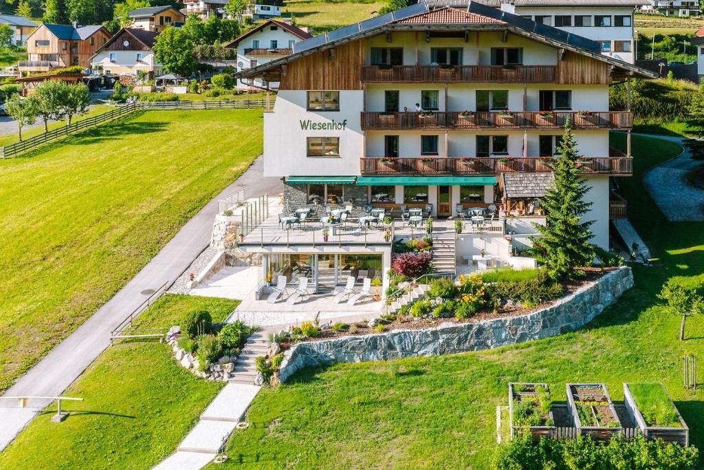 魏森湖Wiesenhof, Hotel direkt am See的享有酒店空中美景,设有草坪