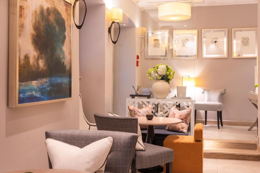 杜布罗夫尼克斯达黎格兰德精品酒店的一间设有椅子和一张桌子的房间,墙上有一个花瓶