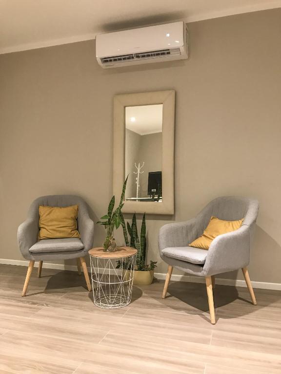 卡塔马卡Confortabile Apart的客厅配有两把椅子和一面镜子
