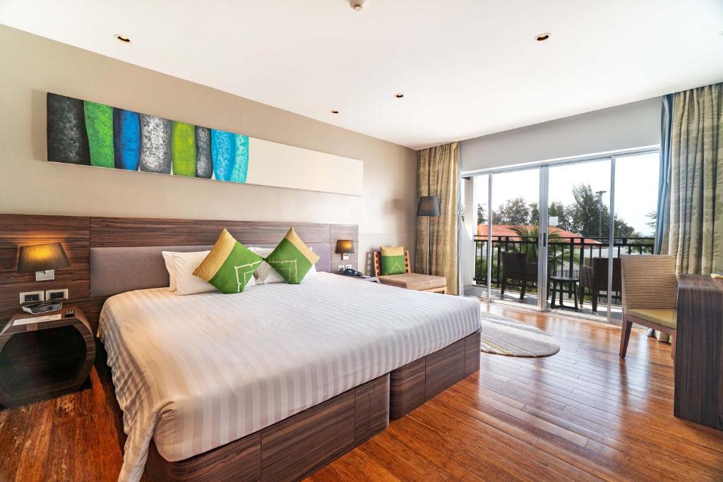 卡伦海滩Holiday Inn Resort Phuket Karon Beach, an IHG Hotel的一间带大床的卧室和一个阳台