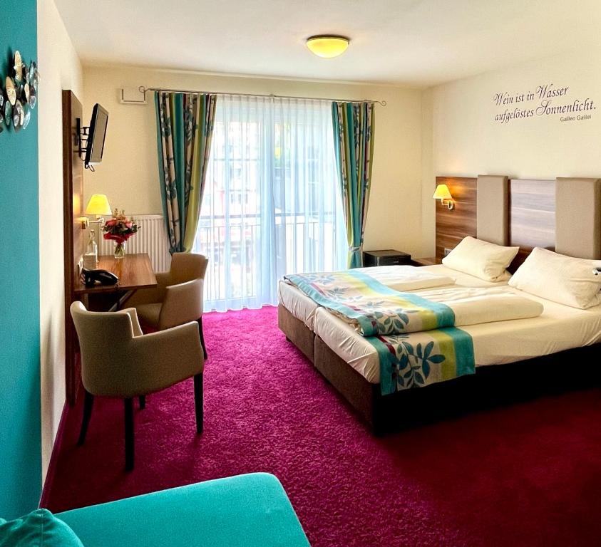吕德斯海姆老德意志葡萄酒吧高级酒店的酒店客房配有一张床铺、一张桌子和一张书桌。