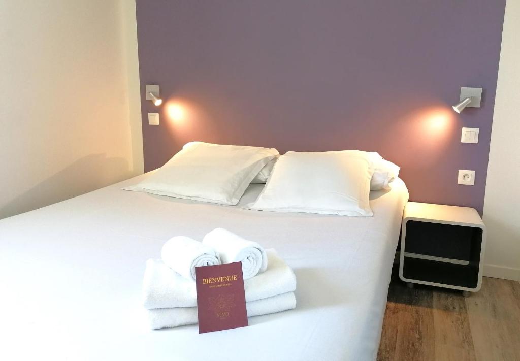 SauvagnonHôtel Némo Aéroport de Pau - KB HOTEL GROUP的酒店客房,配有带毛巾的床