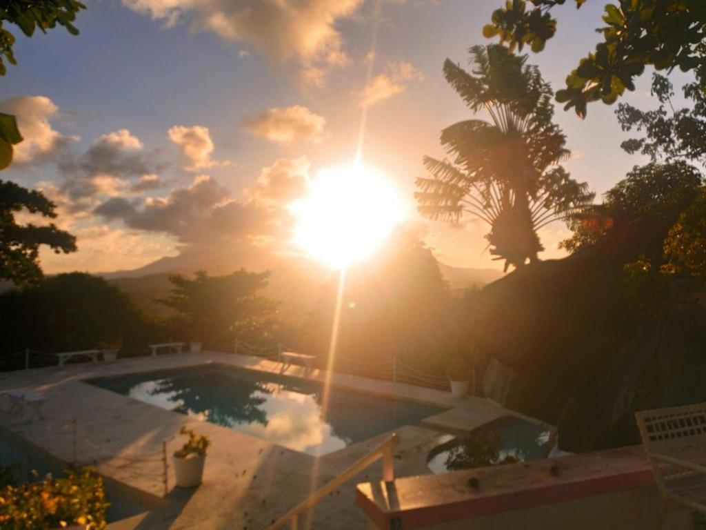 法哈多Kikis Beach House的日落时分,在游泳池边,阳光照耀