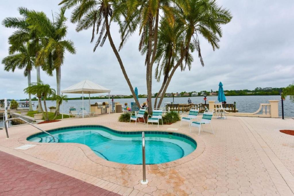 西耶斯塔岛Palm Bay Club的游泳池旁设有椅子和棕榈树