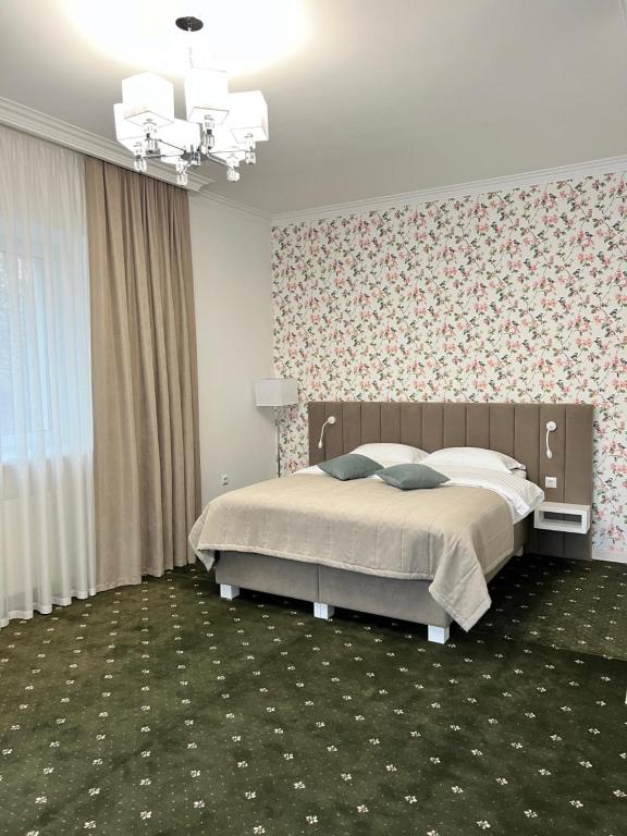 赫梅利尼茨基维克扬酒店的一间卧室设有一张床和花卉墙