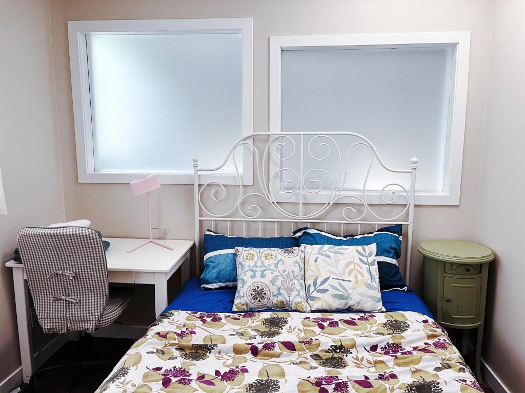 卡尔加里Calgary-Banff single house close LRT&UC&Free Parking的一间卧室配有一张床、一张书桌和两个窗户。
