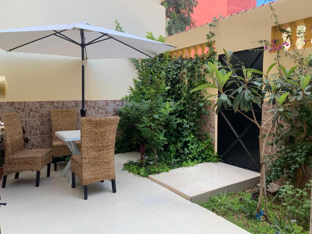 胡塞马Al houceima的庭院配有桌椅和遮阳伞。