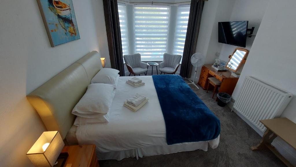 佩恩顿The Clifton at Paignton的一间卧室配有一张床、一张书桌和一台电视
