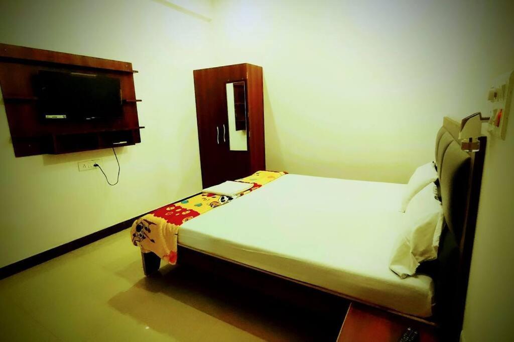瓦拉纳西Champaran Home Deluxe的一间卧室配有一张床和一台平面电视