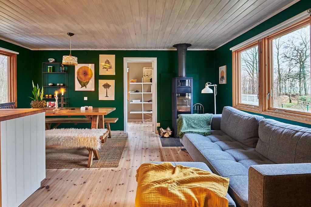 LjungbyhedCosy cabin w fireplace 3 mins from Söderåsen Park的客厅配有沙发和桌子
