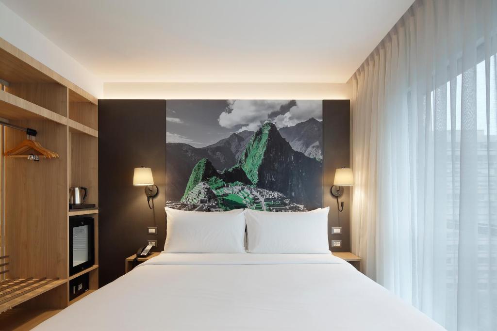 利马Ikonik Miraflores的卧室配有白色的床和山壁画