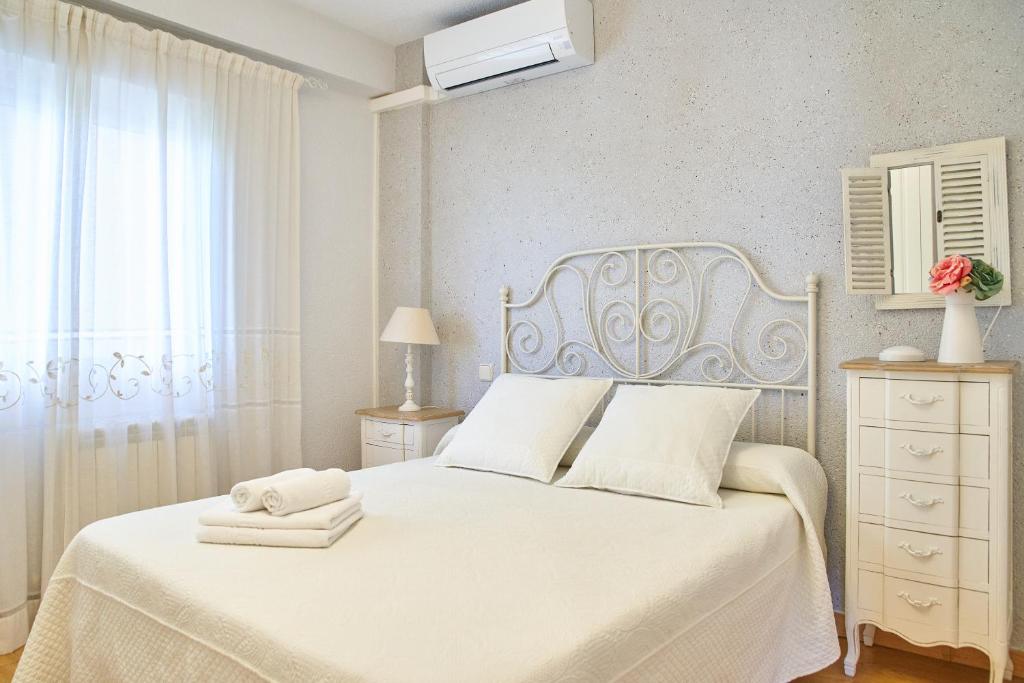 托莱多Lux Buenavista的白色的卧室设有白色的床和窗户。
