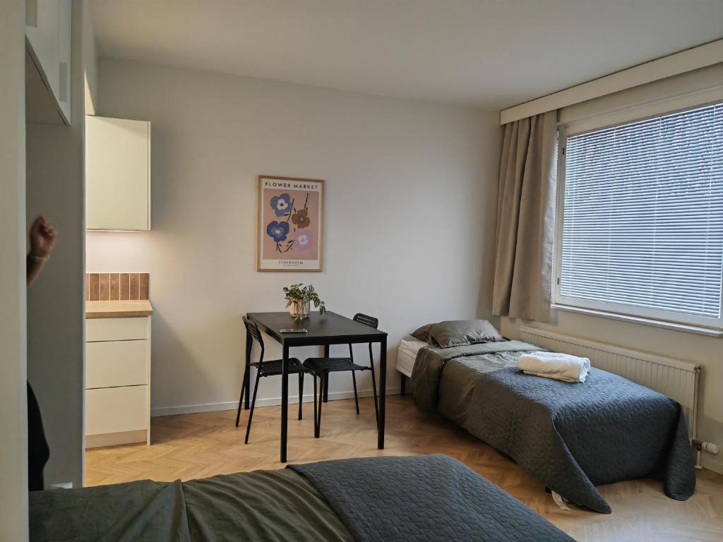 库萨莫New central home的一间卧室设有两张床、一张桌子和一个窗口
