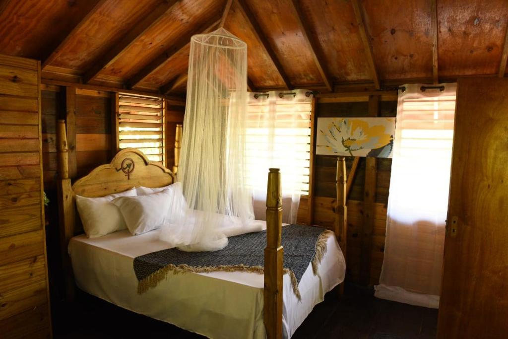 Somali Jungle Eco Lodge and Cabins的小屋内一间卧室,配有一张床