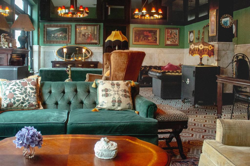 纽约The Nolita Express Hostel的客厅配有绿色沙发和桌子