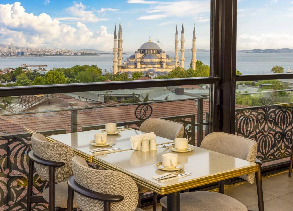 伊斯坦布尔Rast Hotel Sultanahmet的享有清真寺景致的阳台上的桌椅