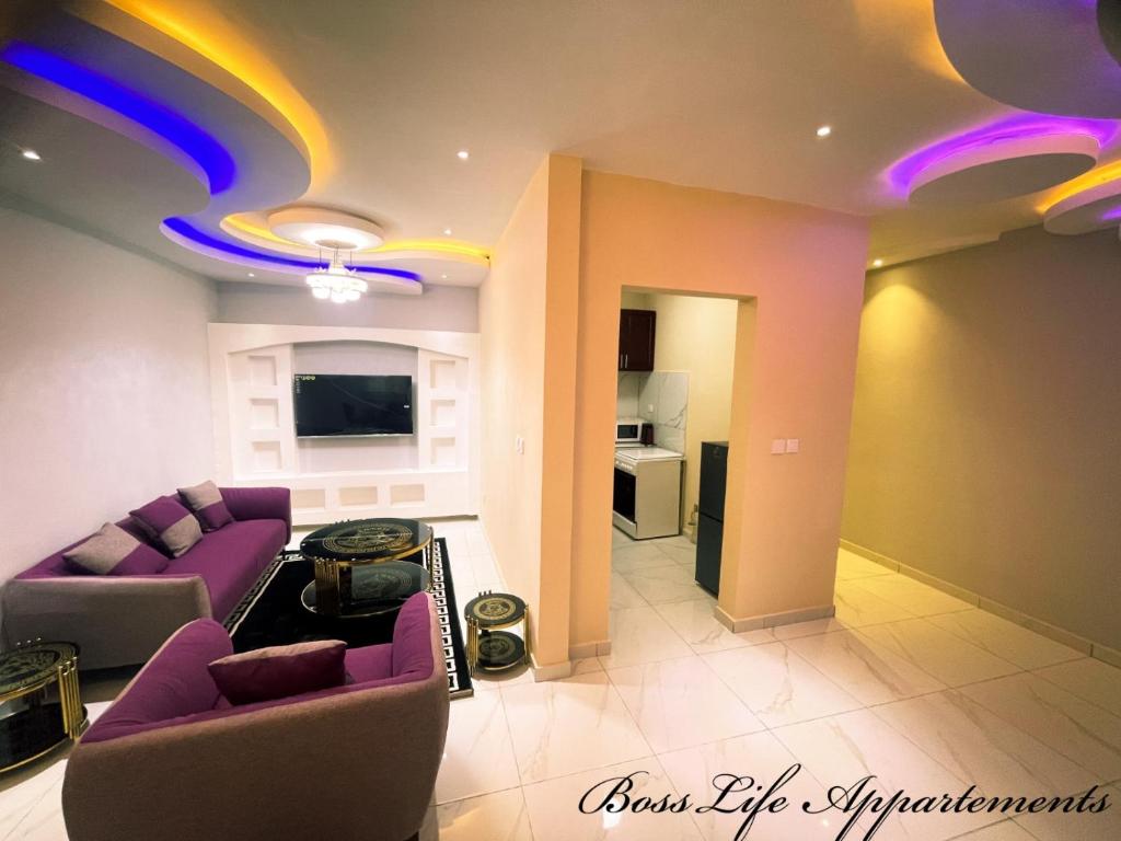 杜阿拉BOSSLIFE APARTMENTS-TERMINUS SAINT MICHEL DERRIERE Barcelone Hôtel的一间带紫色沙发的客厅和一间厨房