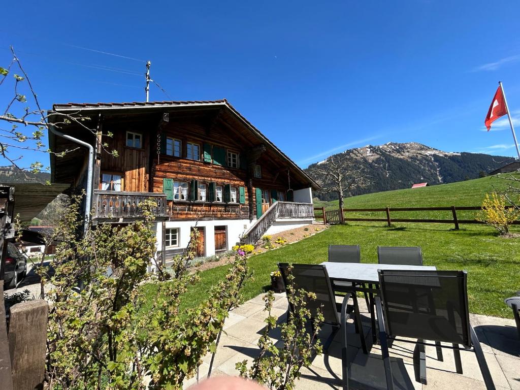 格施塔德Alpenchalet Haldeli Gstaad Ferienwohnung im 1-Stock的房屋前方设有桌椅