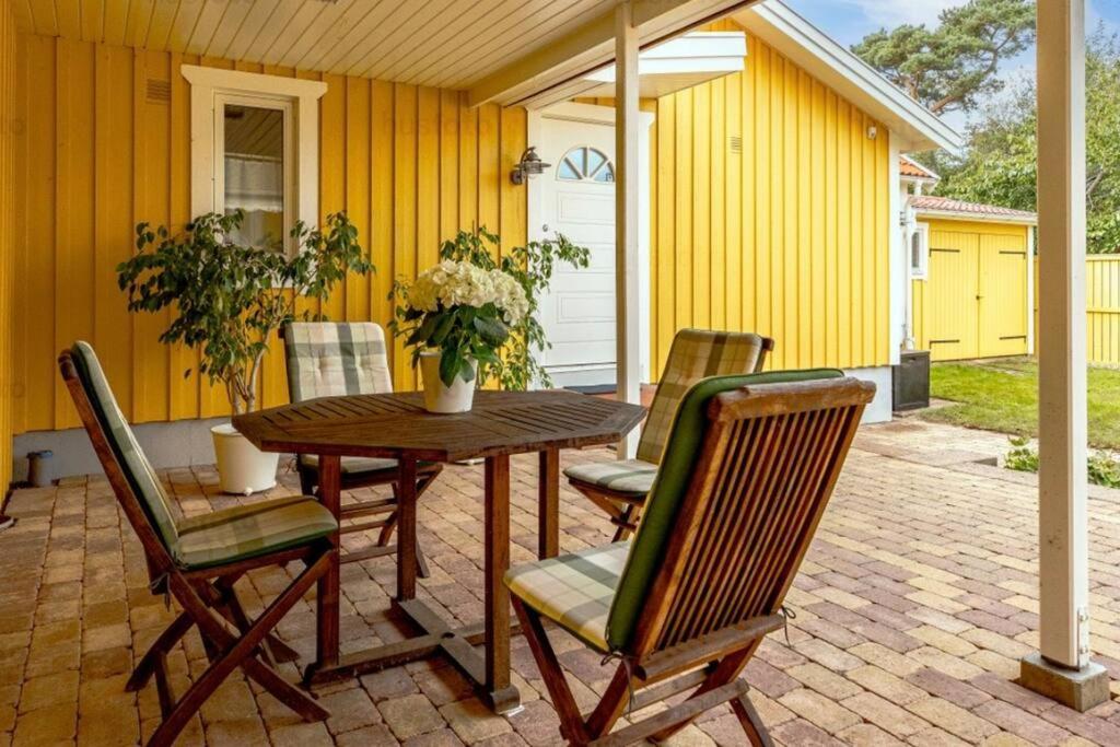 哈尔姆斯塔德Tylösand guesthouse 300m from ocean & golf course的天井上的木桌和椅子