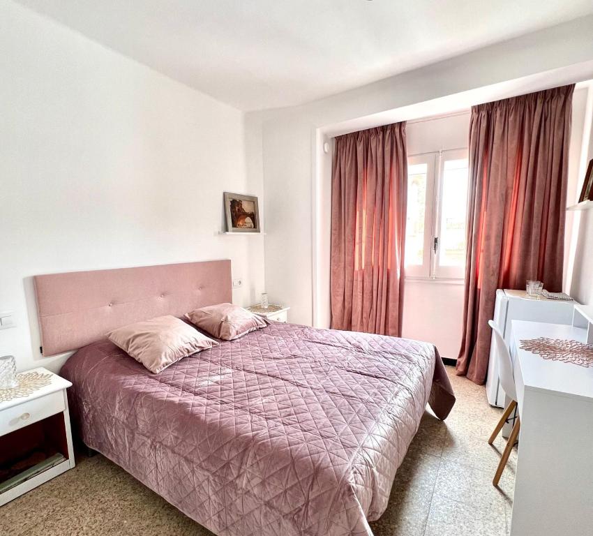 罗萨斯Puig Rom的一间卧室配有一张带紫色床罩的床