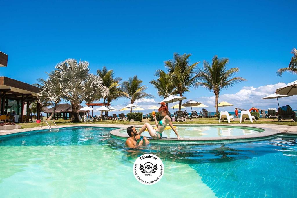 嘎林海斯港Kembali Hotel Porto de Galinhas - Adults Only的两人在度假村的游泳池里
