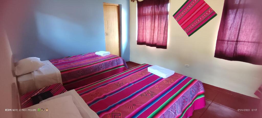 普诺TITICACA'S SALA UTA的一间卧室配有一张带彩色毯子的床