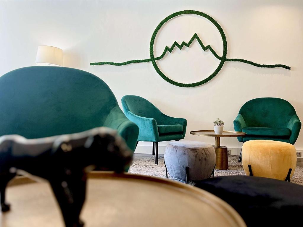 瓦龙Best Western Voiron Centre的客厅配有绿色椅子和桌子