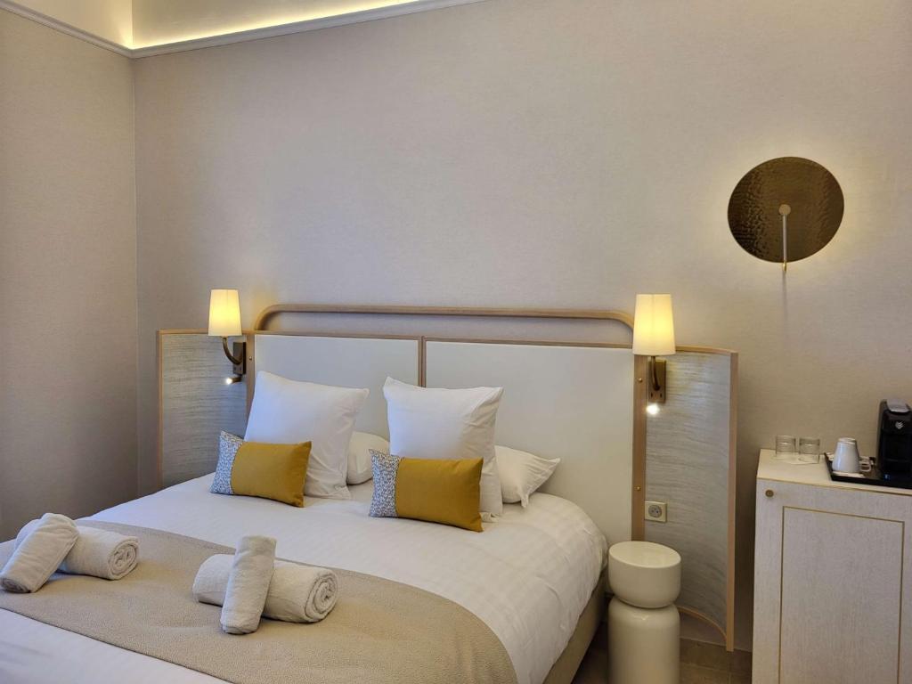 滨海圣西尔莱克斯大酒店的一间卧室配有一张带黄色和白色枕头的大床