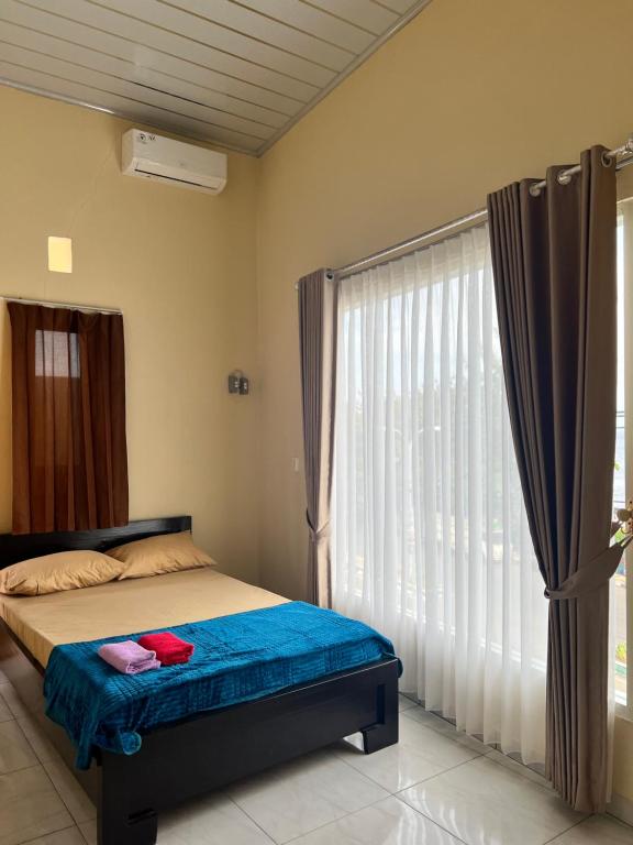 特尔纳特岛KBI Hostel的一间卧室设有一张床和一个大窗户