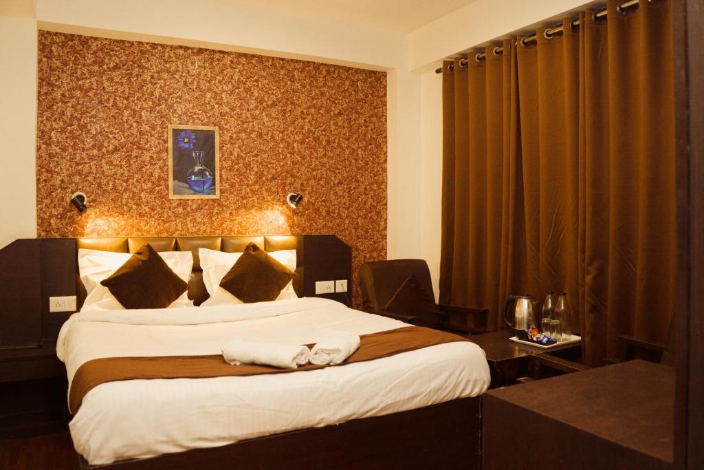甘托克Hotel Siddhi Vinayak Regency,near Mg Marg, Gangtok的酒店客房带一张大床,带白色床单