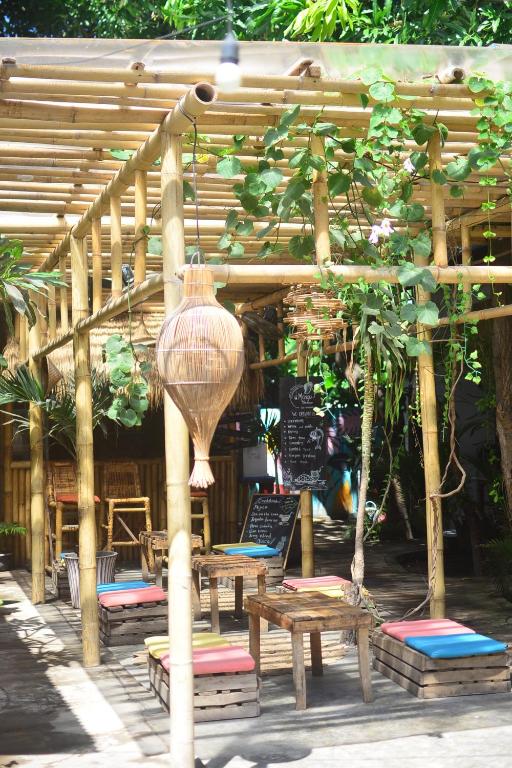 吉利特拉旺安Mango Tree House的木凉亭,带长椅和桌子,花瓶