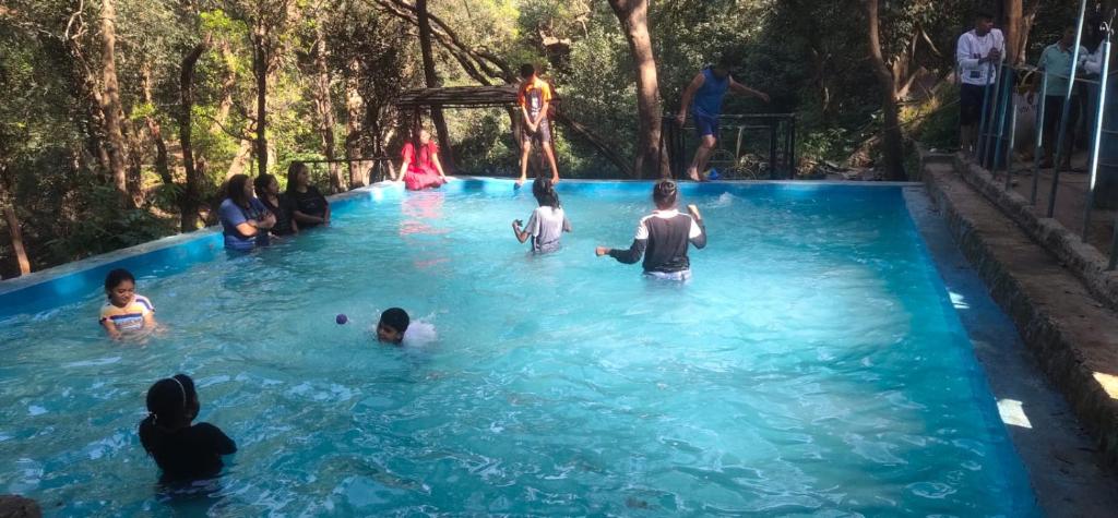 马泰兰Hilltone Resort matheran的一群人在游泳池玩耍