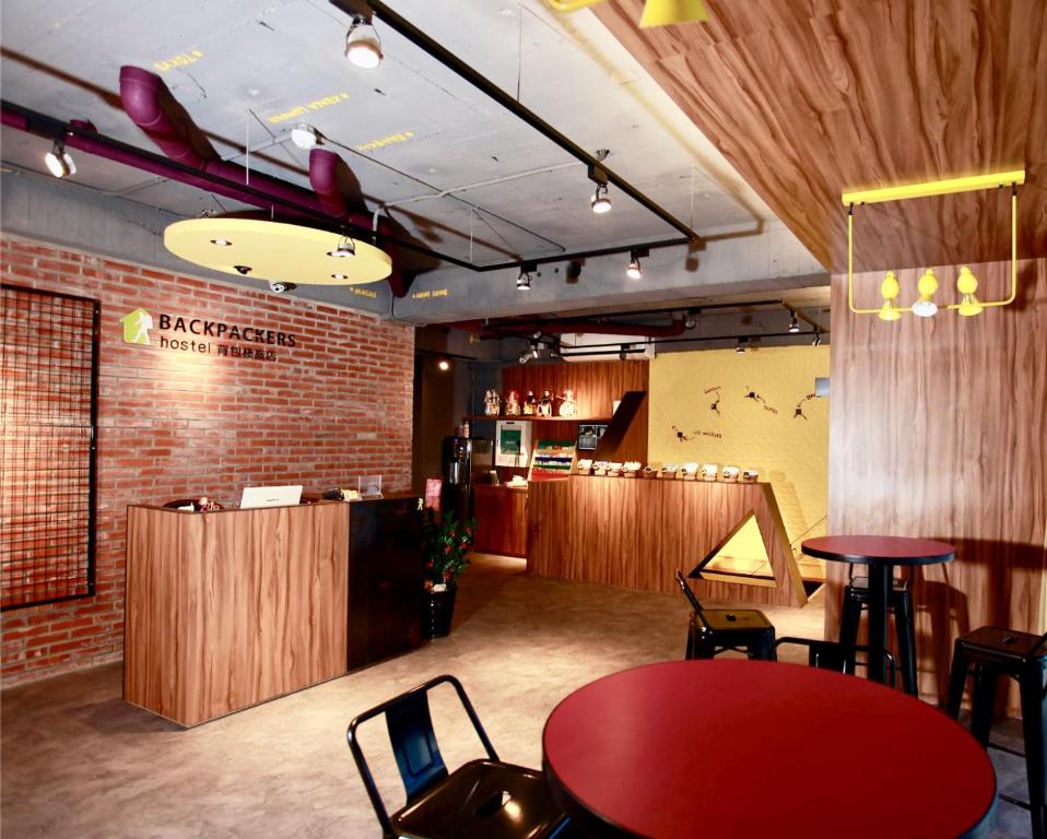 台北背包棧旅店- 西门町馆的餐厅设有红色的桌子、椅子和柜台