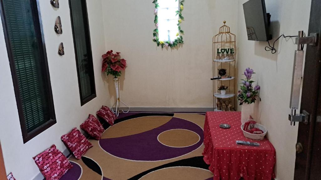 GeruntangVallery homestay的一间带红色桌子的客厅和一间带地毯的房间