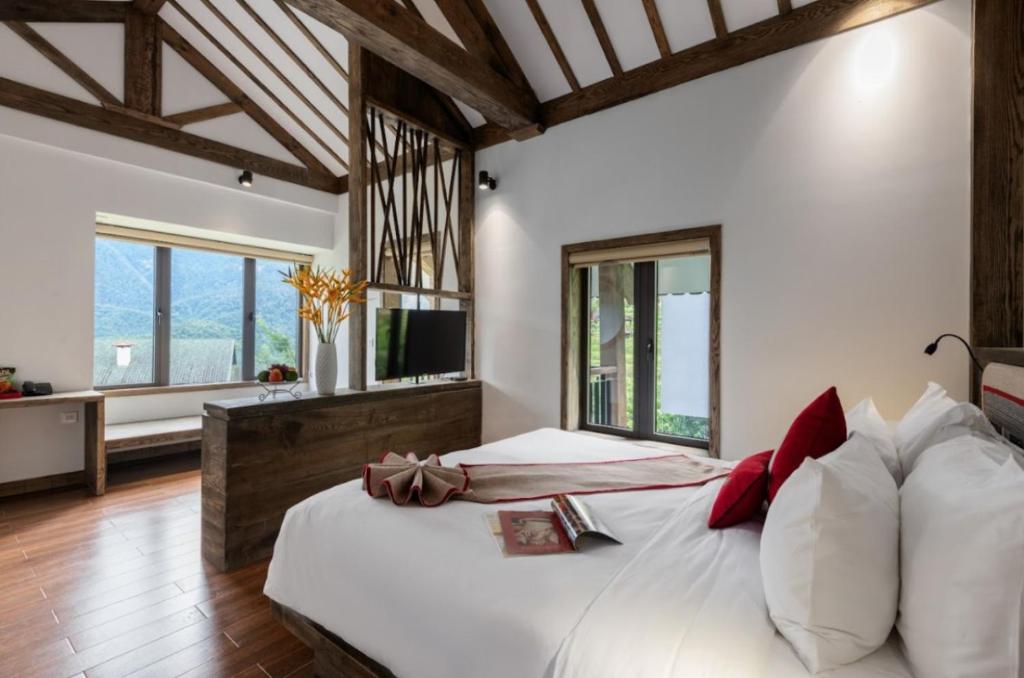 萨帕Sapa Catcat Hills Resort & Spa的卧室设有白色大床和窗户。