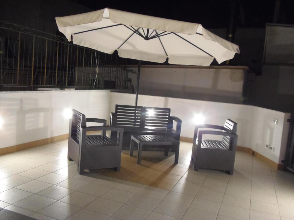 卡斯泰拉内塔B&B LuiRò的一张桌子和两把椅子及雨伞