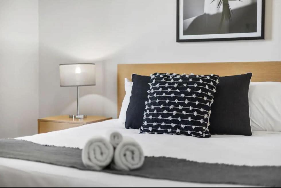 珀斯Executive Apt - 2BR 1BA w Parking的一间卧室配有一张床,上面有两条毛巾