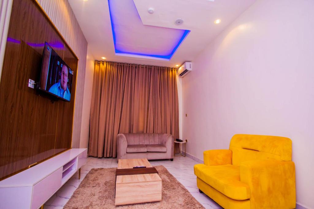 拉各斯Soulmate Hotels & Suites的客厅设有黄色沙发和电视