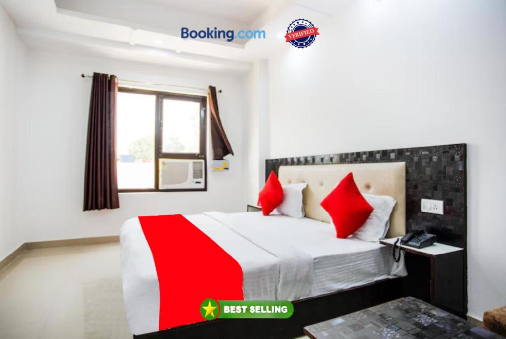 哈里瓦Hotel Raj Ganga Haridwar Near Raja Ji National park Jeep Safari - Excellent Customer Choice- Best Seller的配有红色枕头的床的酒店客房