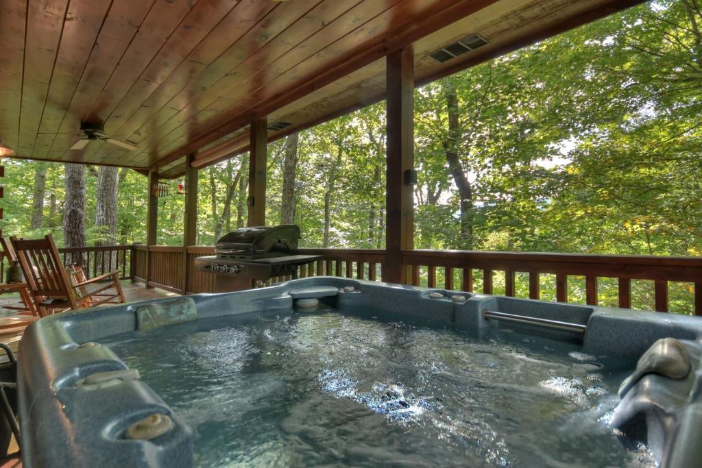 埃利杰Bearfoot Ridge Wood-burning fireplace cozy hot tub serene views的小屋甲板上的热水浴池