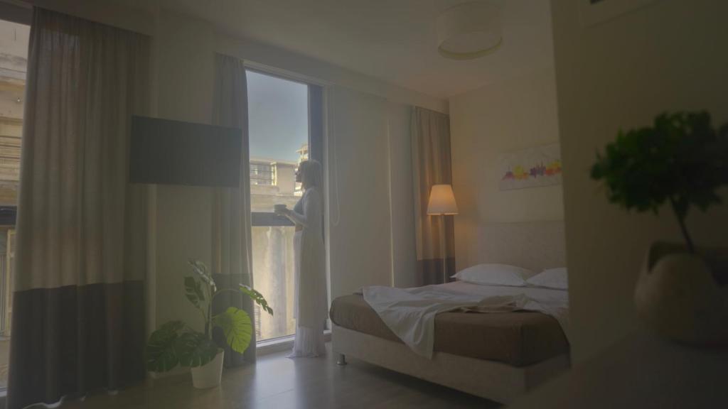 雅典Tins Hotel City - Athens的一间卧室设有一张床和一个大窗户
