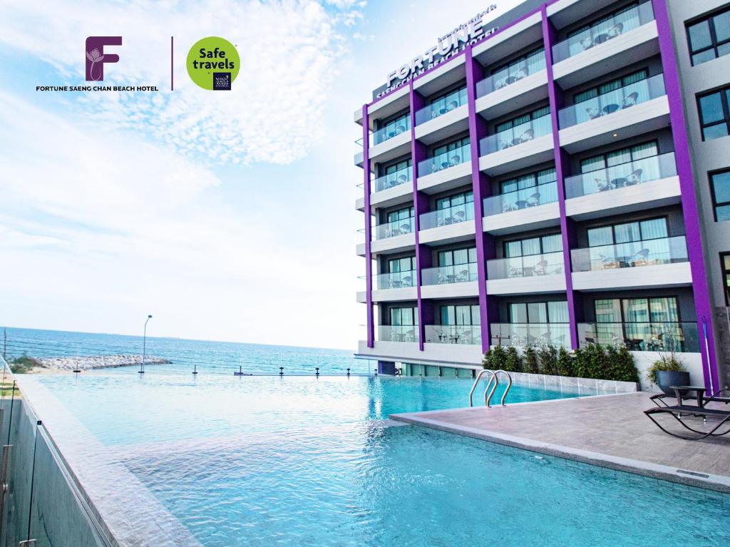 罗勇Fortune Saeng Chan Beach Hotel Rayong - SHA Plus的大楼前设有游泳池的酒店