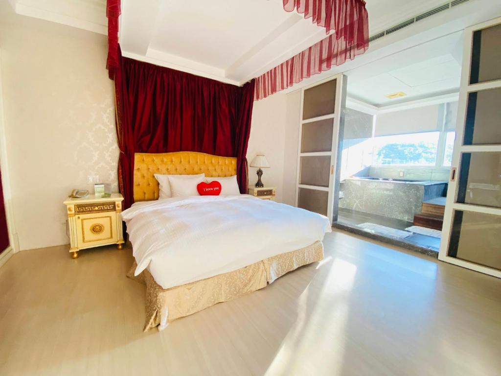 杨梅丽多森林温泉酒店(原东森山林渡假酒店)的一间卧室配有一张带红色窗帘的大床