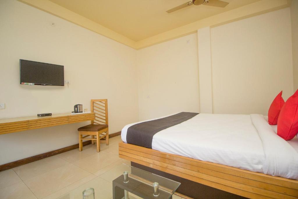Ingrāj BāzārFlagship 43145 Mayaban Resort的一间卧室配有一张床和一张书桌及电视
