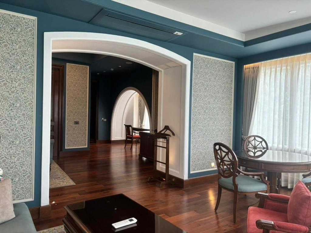 穆索里Welcomhotel by ITC Hotels, The Savoy, Mussoorie的客厅拥有蓝色的墙壁和桌椅