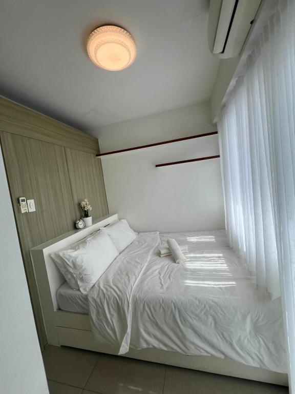 马尼拉1br Shore Residences Staycation at Royels Place的卧室配有白色的床和窗户